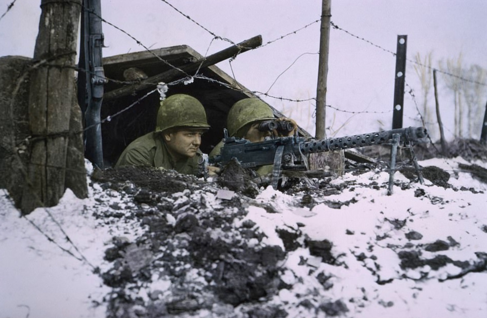 Two soldiers take up gunning positions in a bunker 